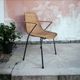 Vintage wicker chair with black steel frame and armrests