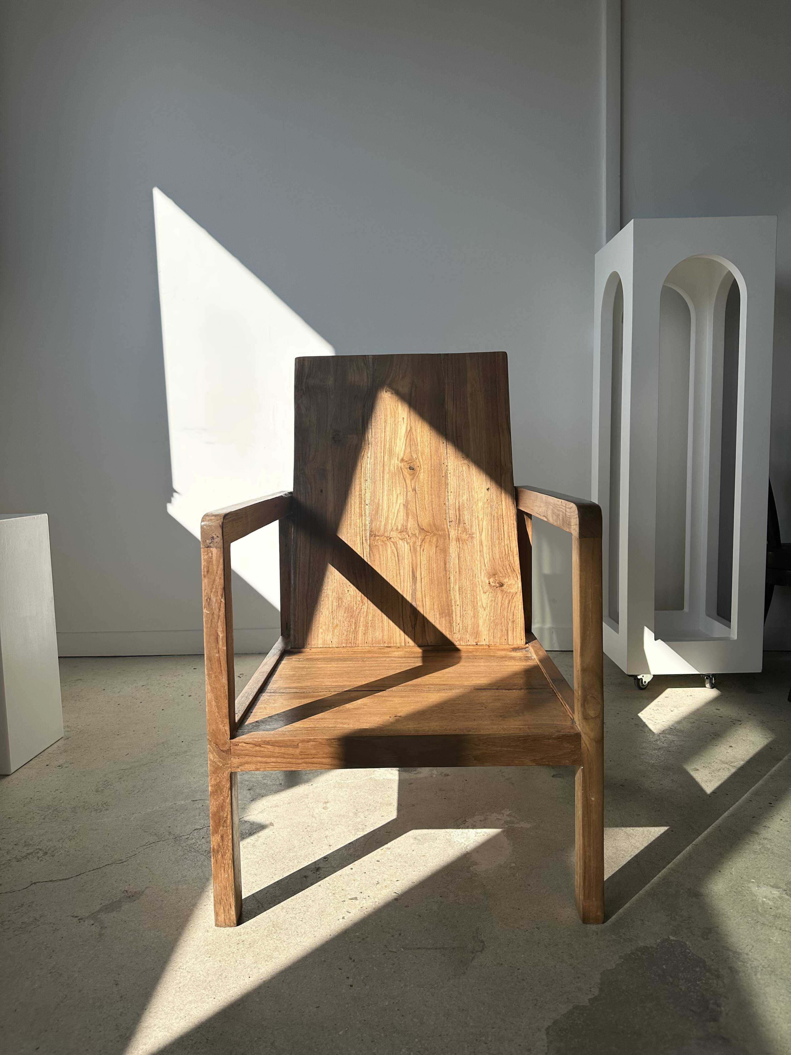 Large armchair in natural wood (teak) with a minimalist design.