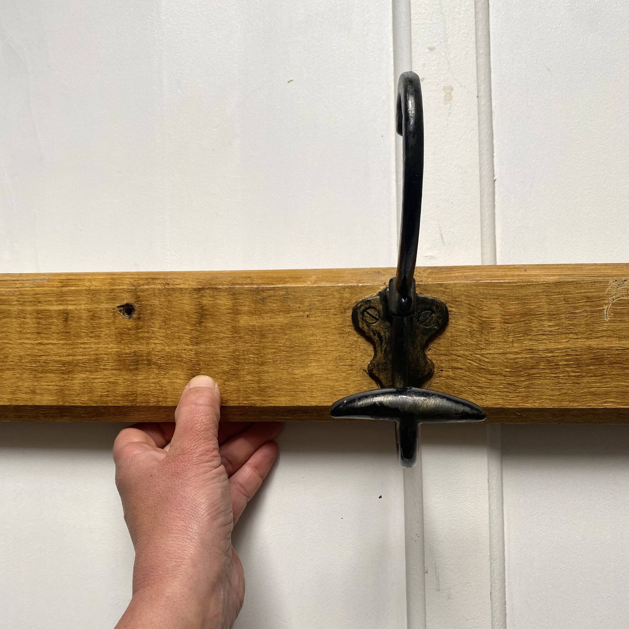 Antique wooden coat rack with metal hooks