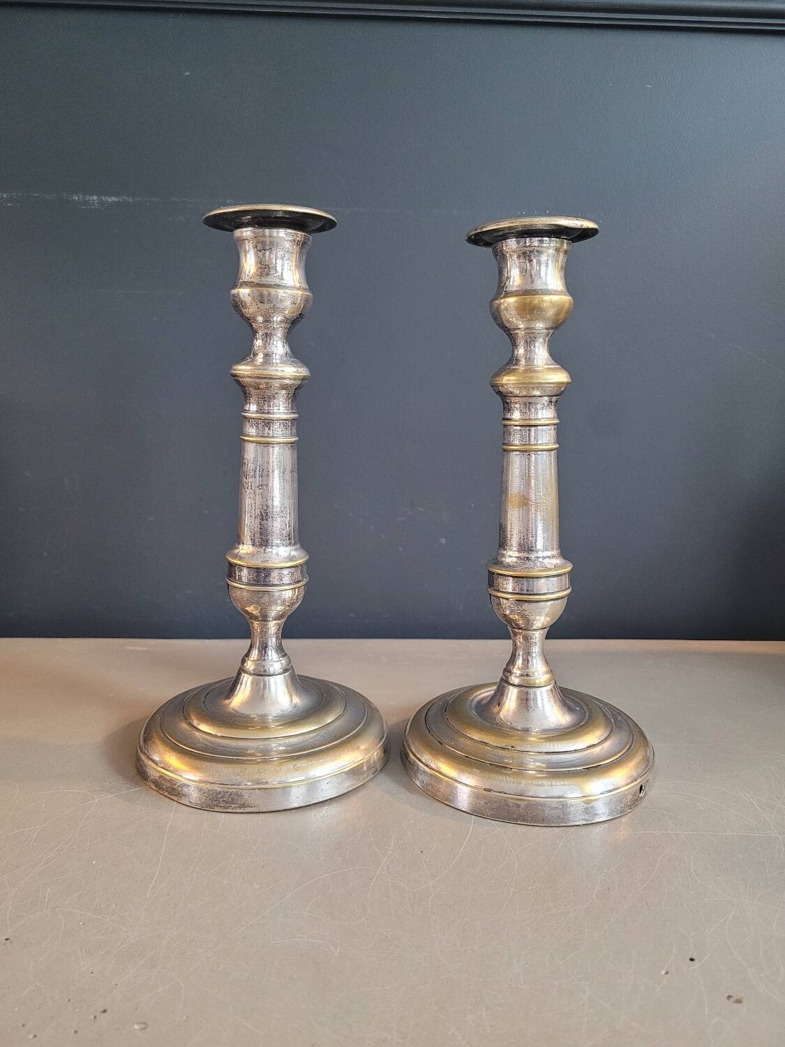 Paire de bougeoirs anciens en laiton argenté