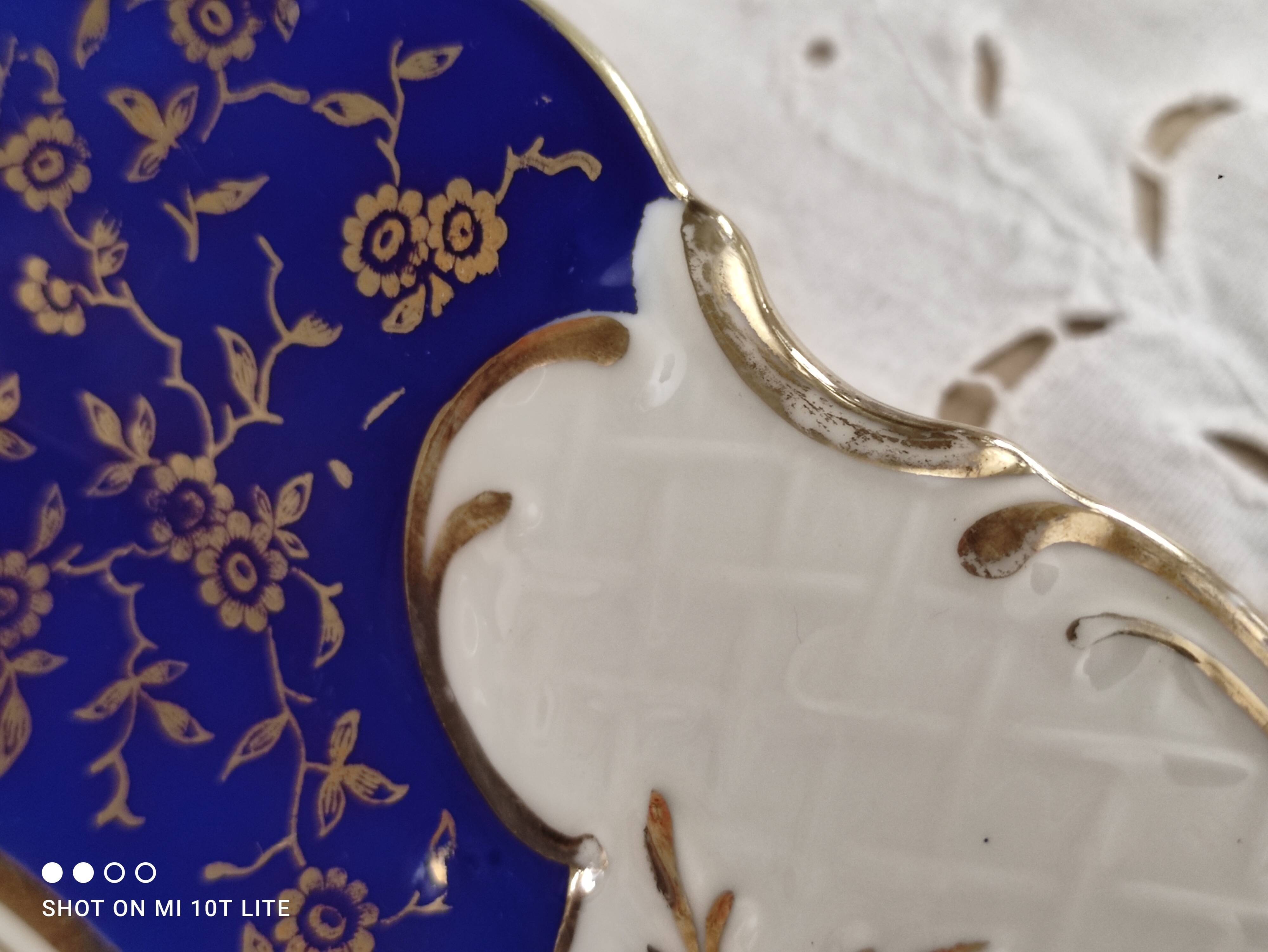 Plat rond creux en porcelaine allemande bleu nuit et motifs floraux polychromes et dorés