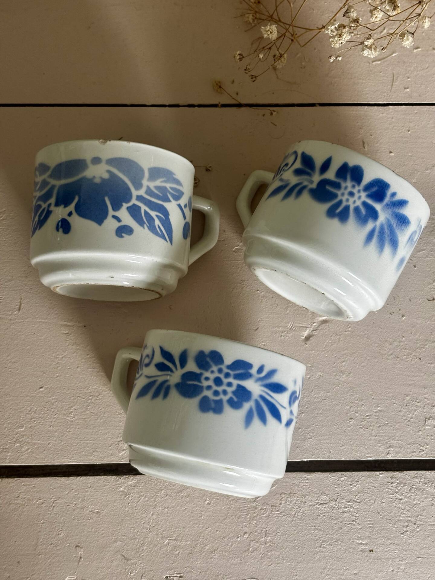 Set of 3 antique ceramic cups with blue floral pattern.