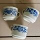Set of 3 antique ceramic cups with blue floral pattern.