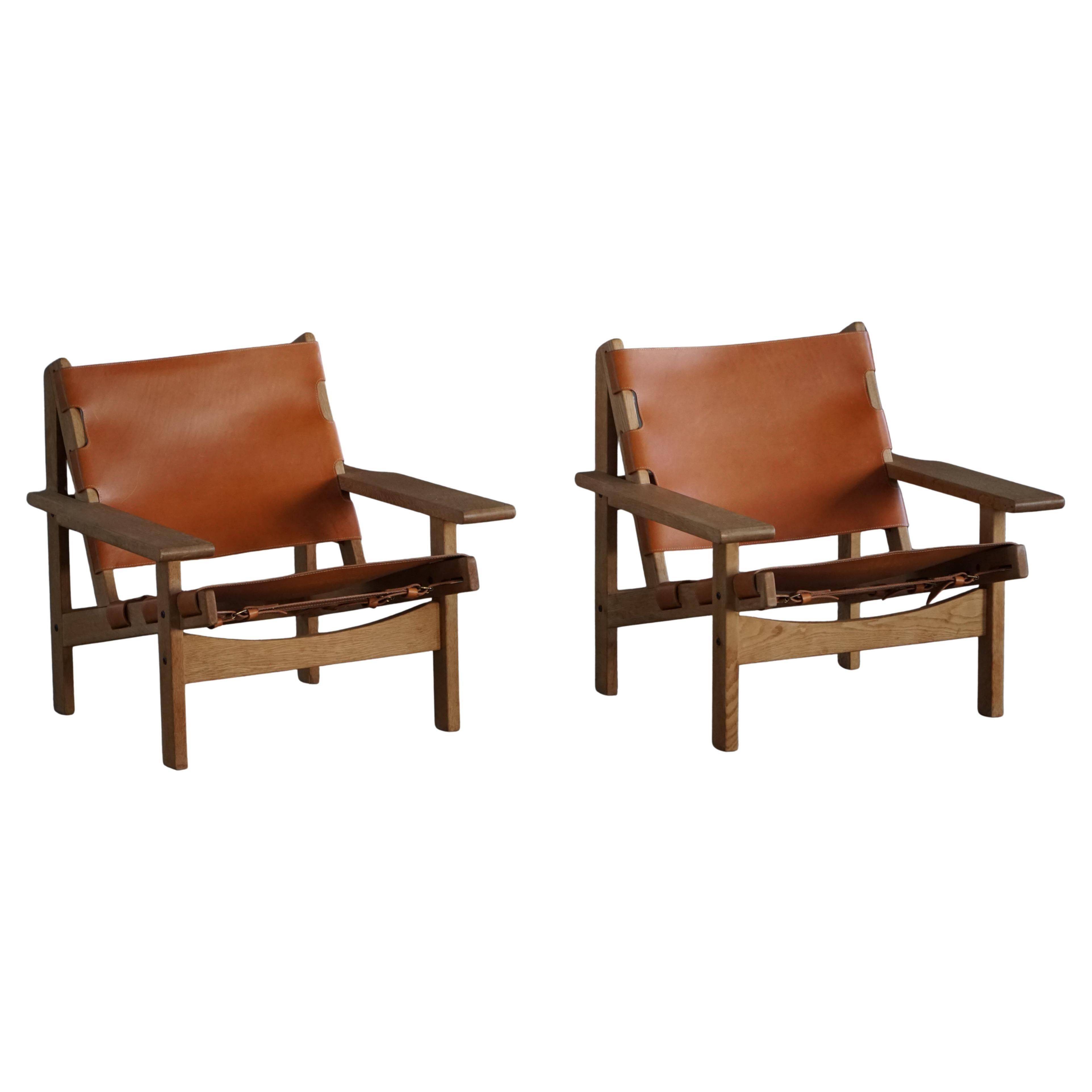 Pair of oak and leather hunting chairs by Kurt Østervig, modern Danish style from the 1960s.