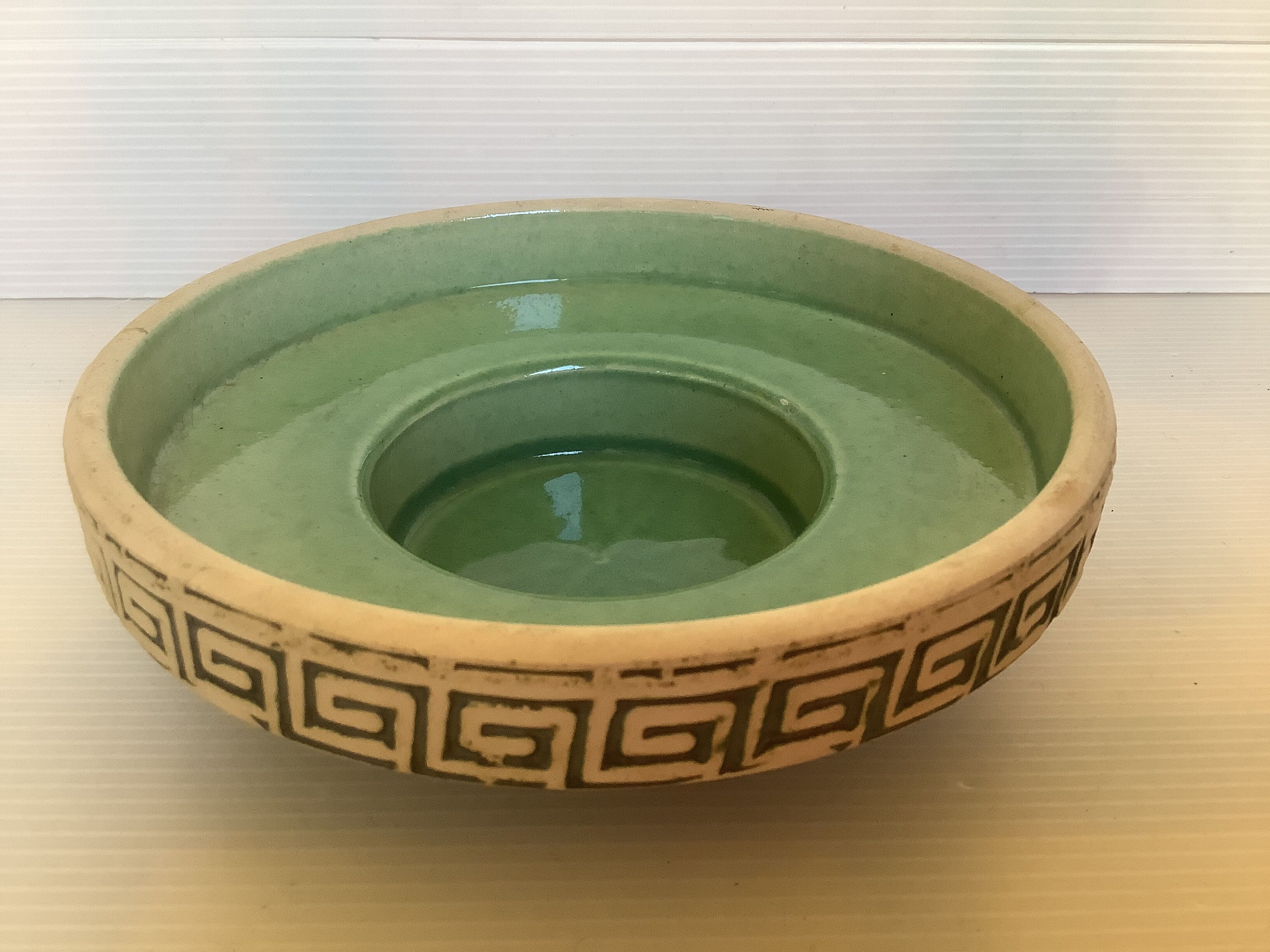 Green ceramic candle holder with a frieze
