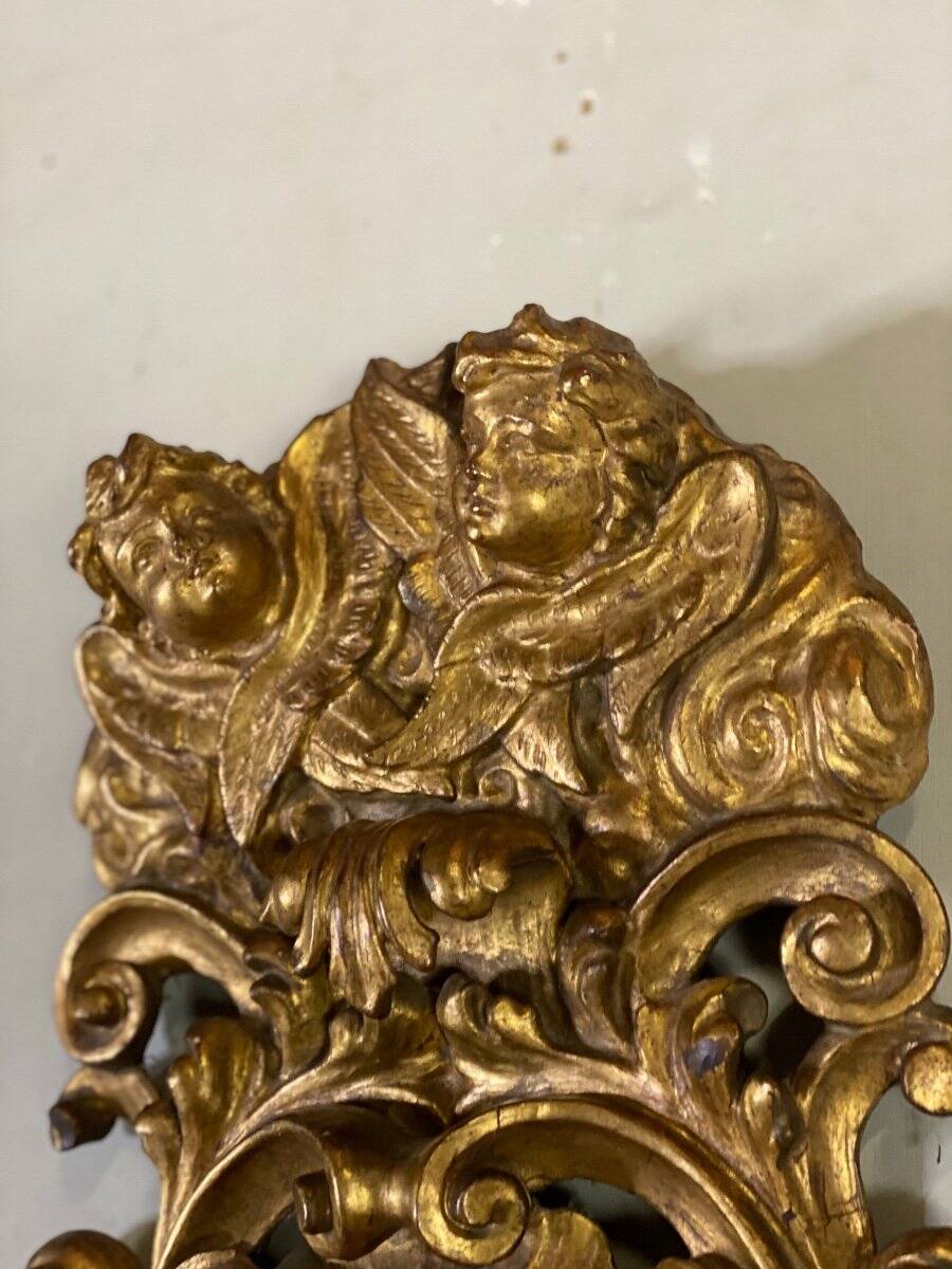 Paire d’appliques en bois sculpté et doré surmontées de deux têtes d’angelots, Italie