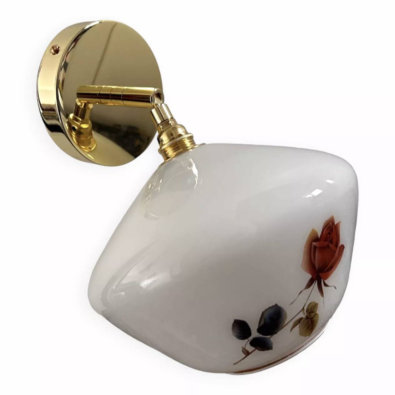 Golden tilting wall light with flowered globe