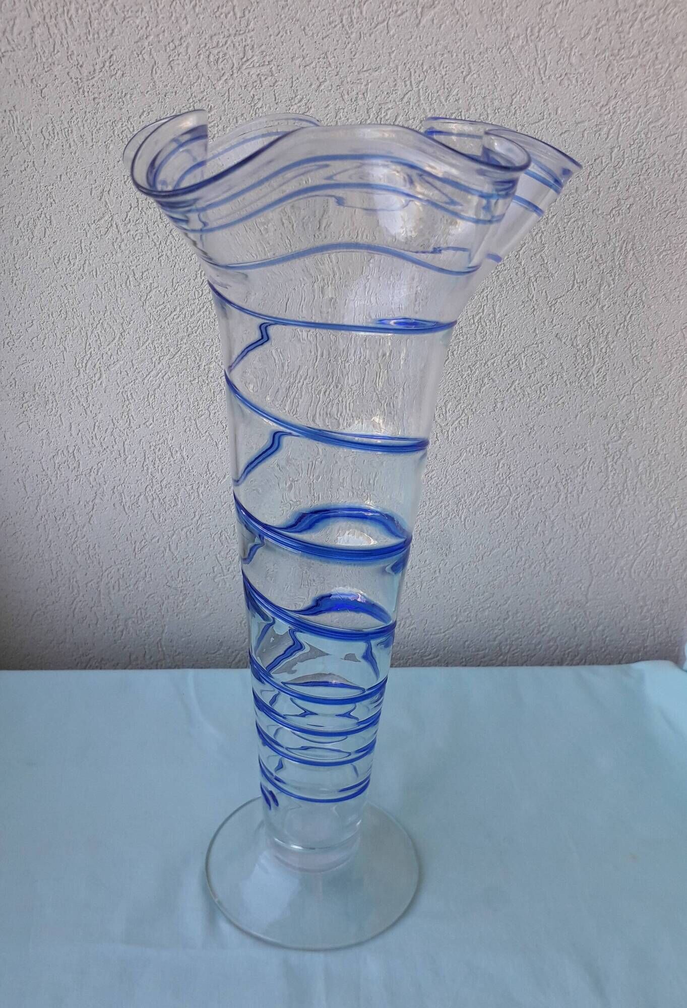 Glass vase on a pedestal with a blue trim.