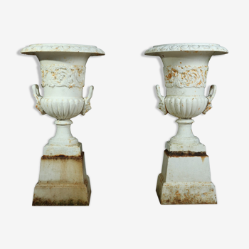 Pair of cast iron urns on plinth