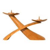 Sculptural wooden candlestick in the shape of a boomerang, handcrafted from carved wood, in mid-century modern style.