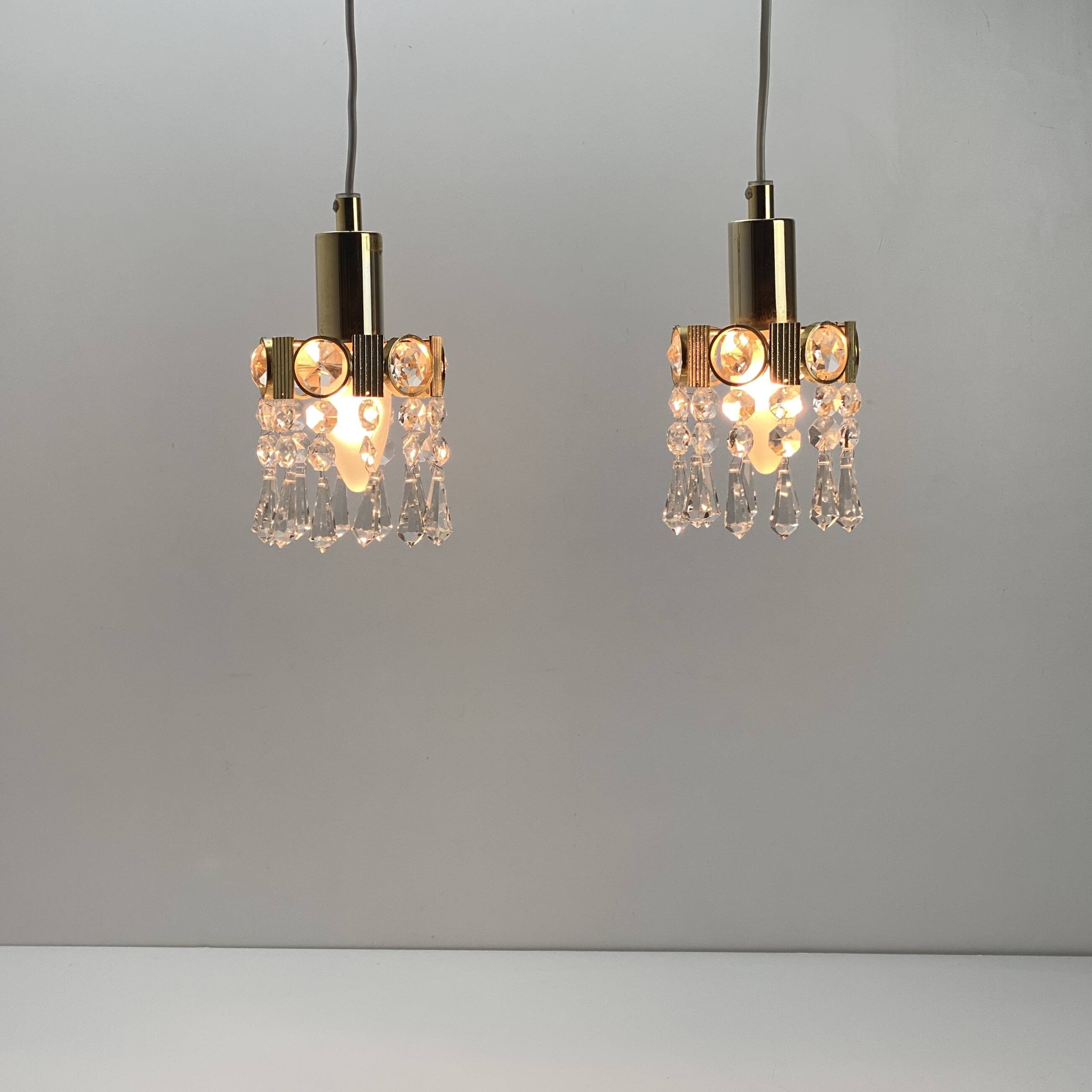 Two gold-plated brass and crystal pendant lights, by Palwa, 1960s design, Hollywood Regency.