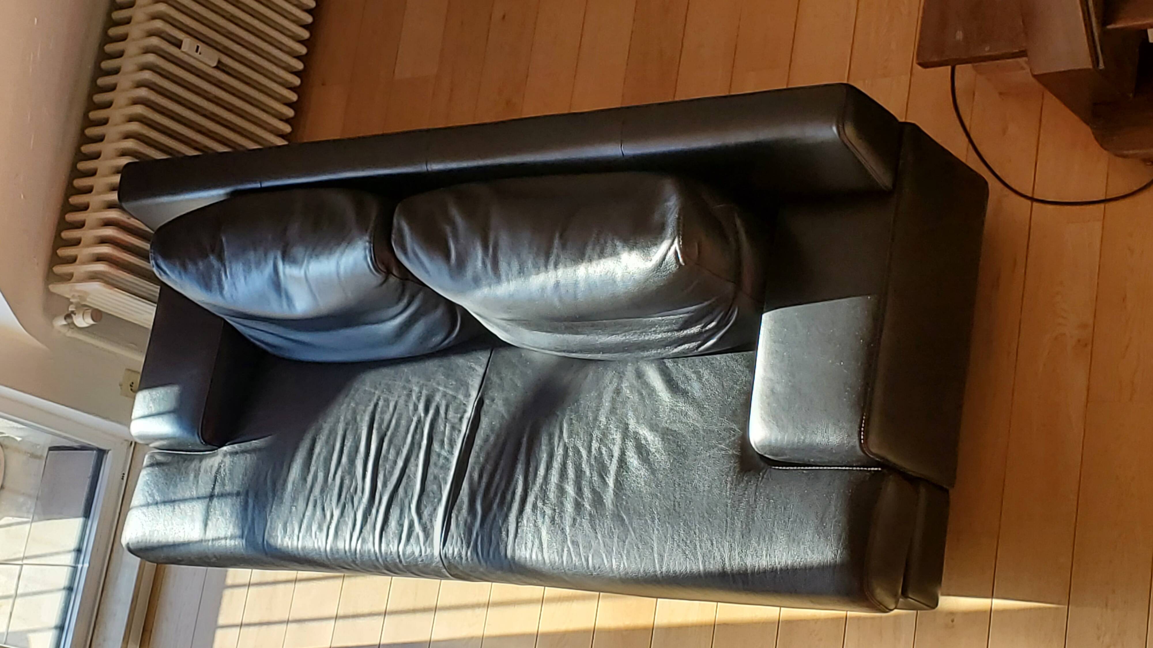 Black leather three-seater sofa