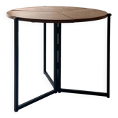 Modernist round folding dining table in wood and metal.