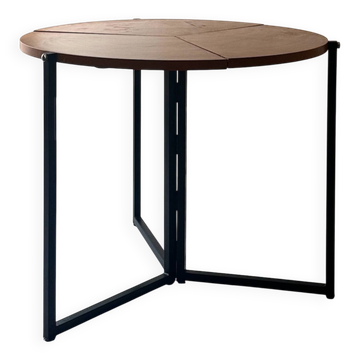 Modernist round folding dining table in wood and metal.