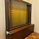 Vintage wooden and glass display cabinet, 15 shelves, gold background.