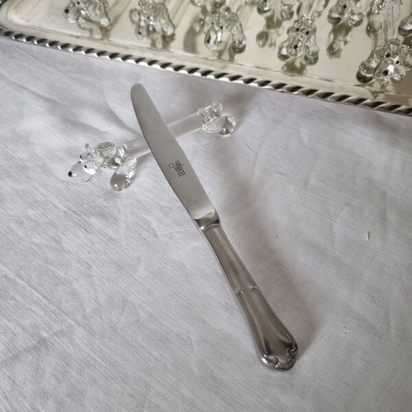 Un charmant coffret de 12 couteaux en verre moulé repose en forme de chien