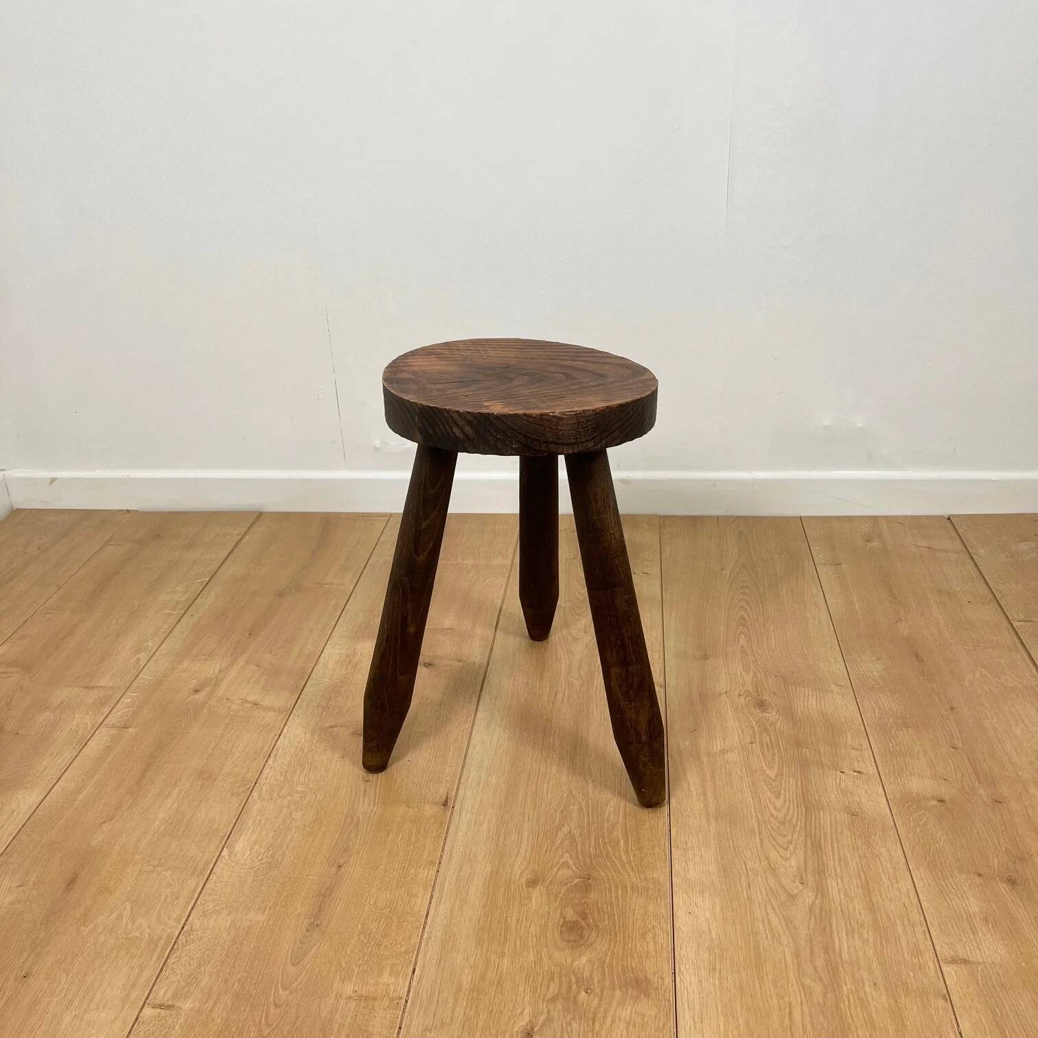 Petit tabouret tripode brutaliste en bois massif