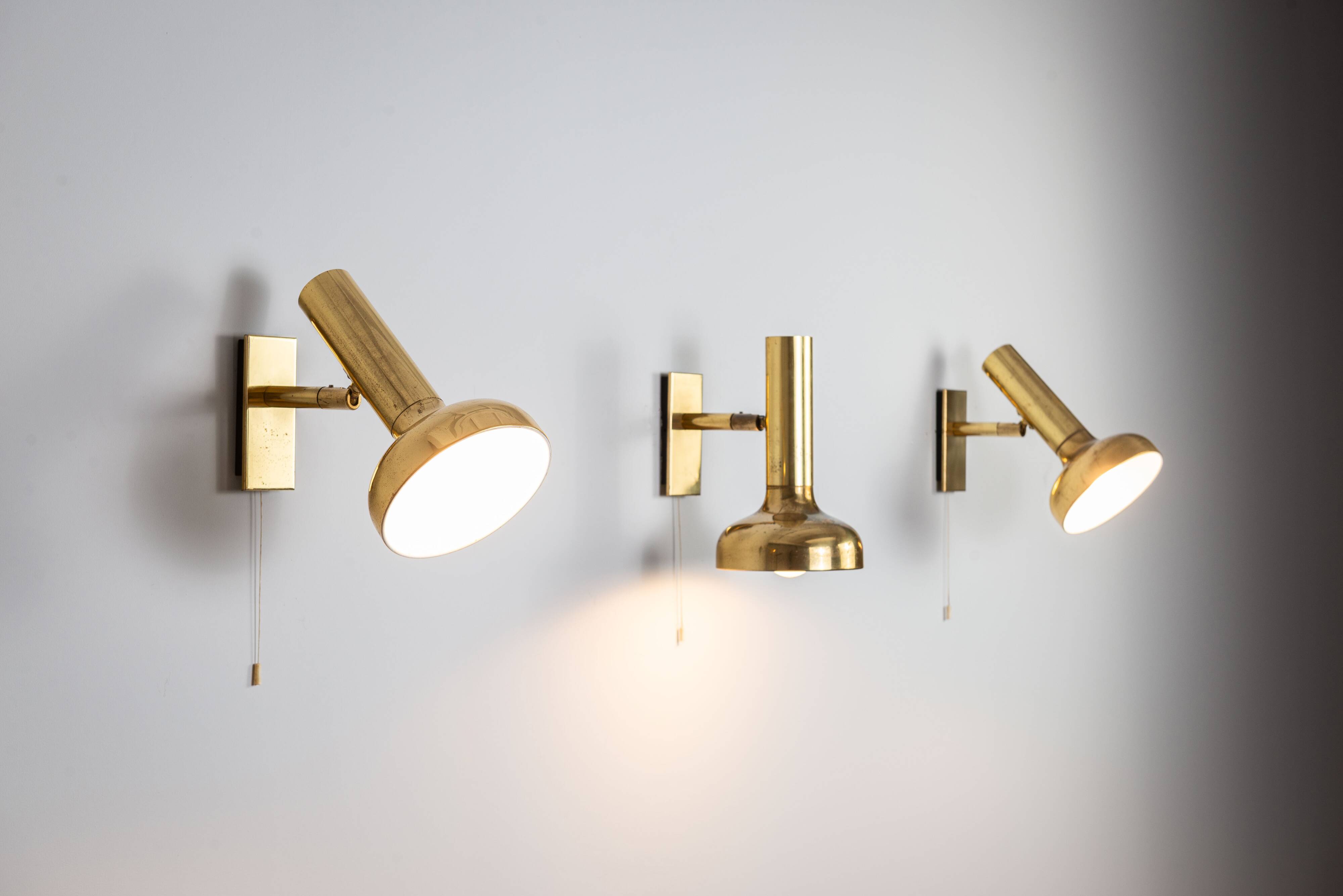 Set of three brass adjustable wall lamps