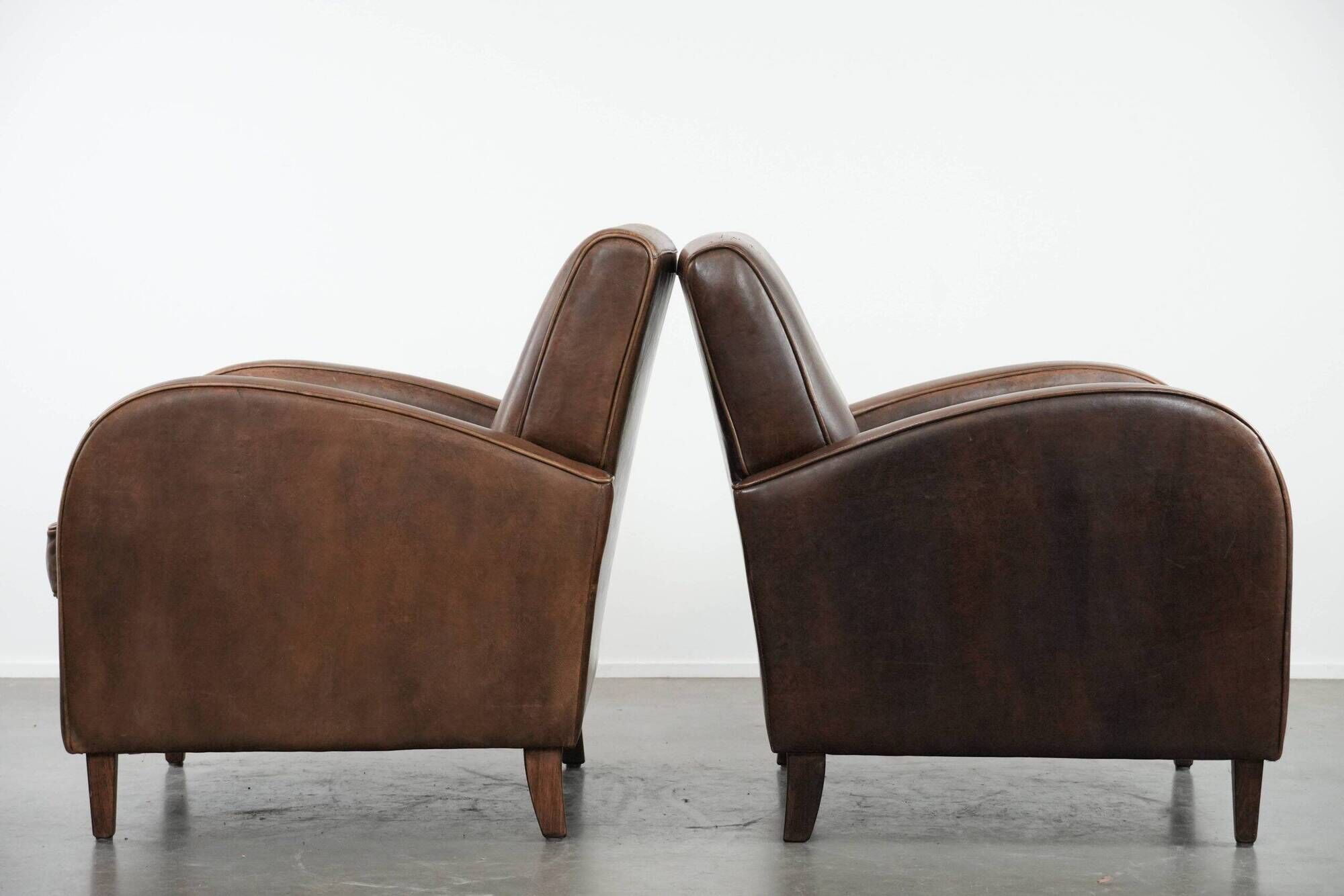 Elegant set of two sheepskin leather armchairs with beautiful round shapes