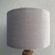 Wooden turned totem lamp with a linen shade in a vintage Scandinavian style.