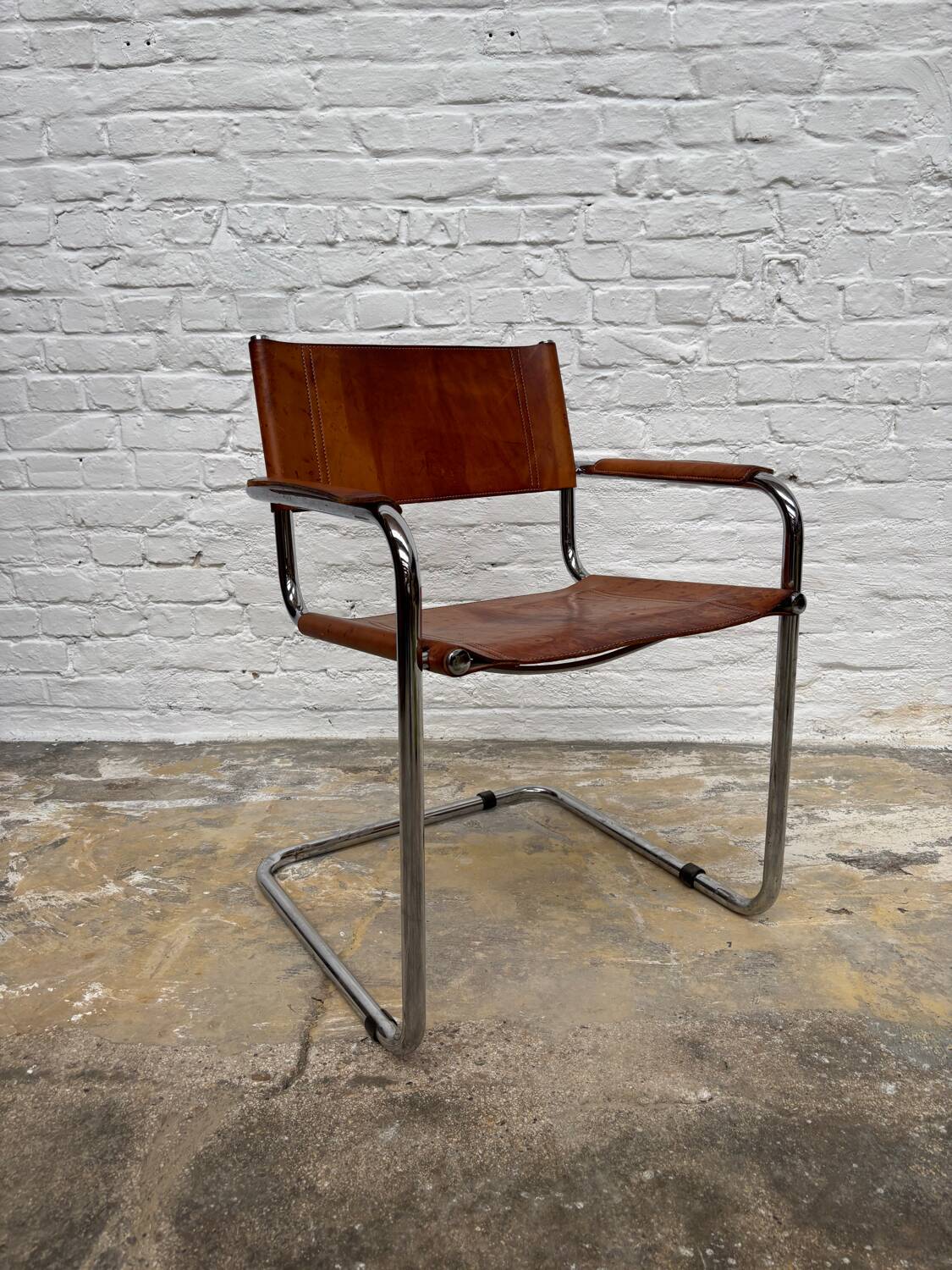 Vintage aluminum tube and tan leather armchair