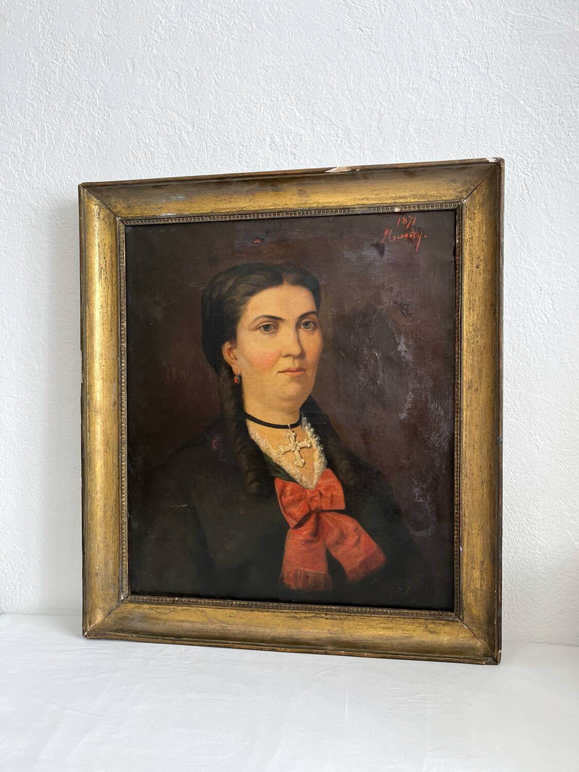 Old oil painting on canvas portrait of a woman with a red bow, late 19th century