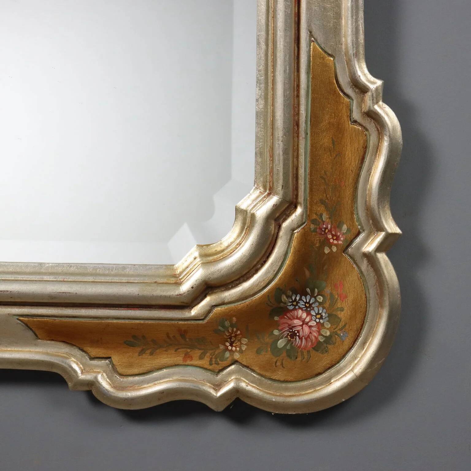 Antique mirror with a gilded frame and floral decorations, Italy, 20th century.
