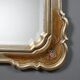 Antique mirror with a gilded frame and floral decorations, Italy, 20th century.