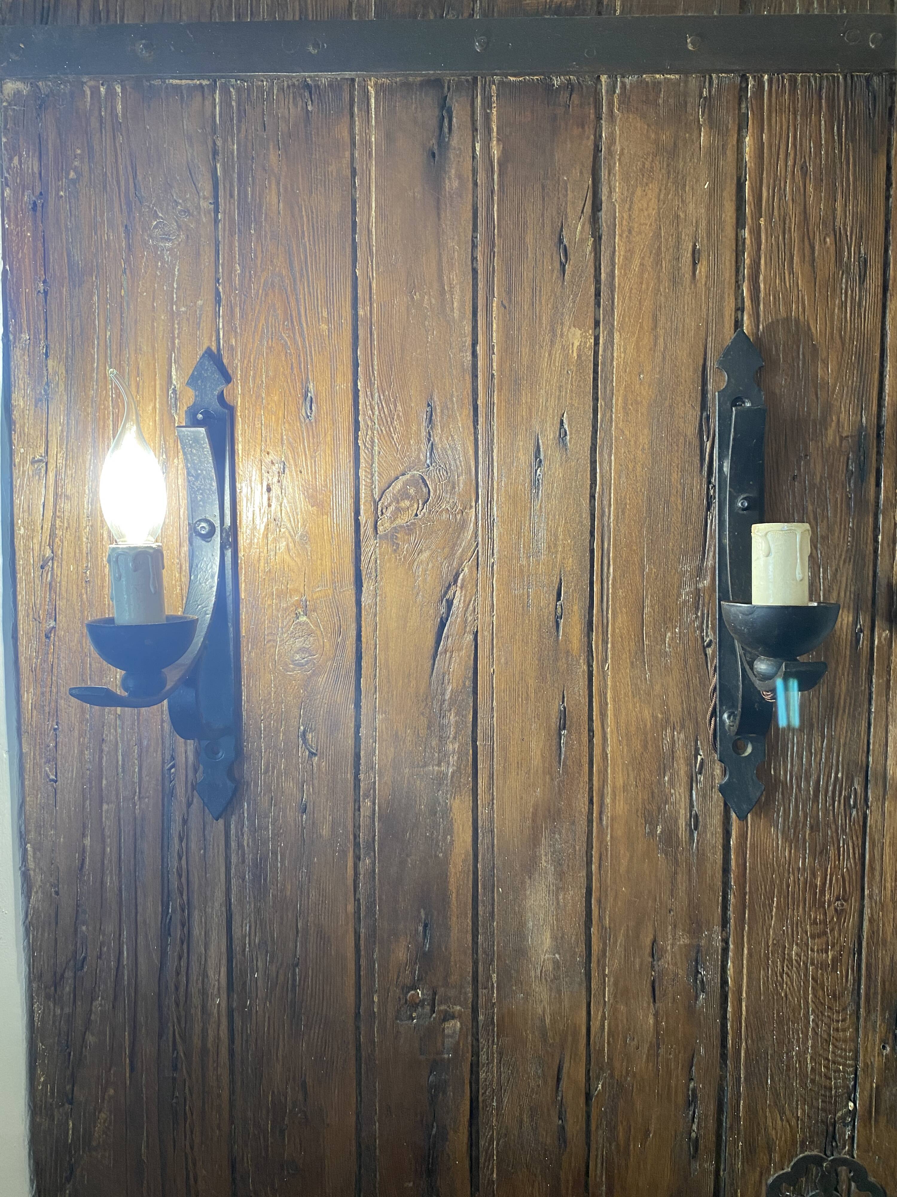 Two wrought iron wall lights, fabric cable.