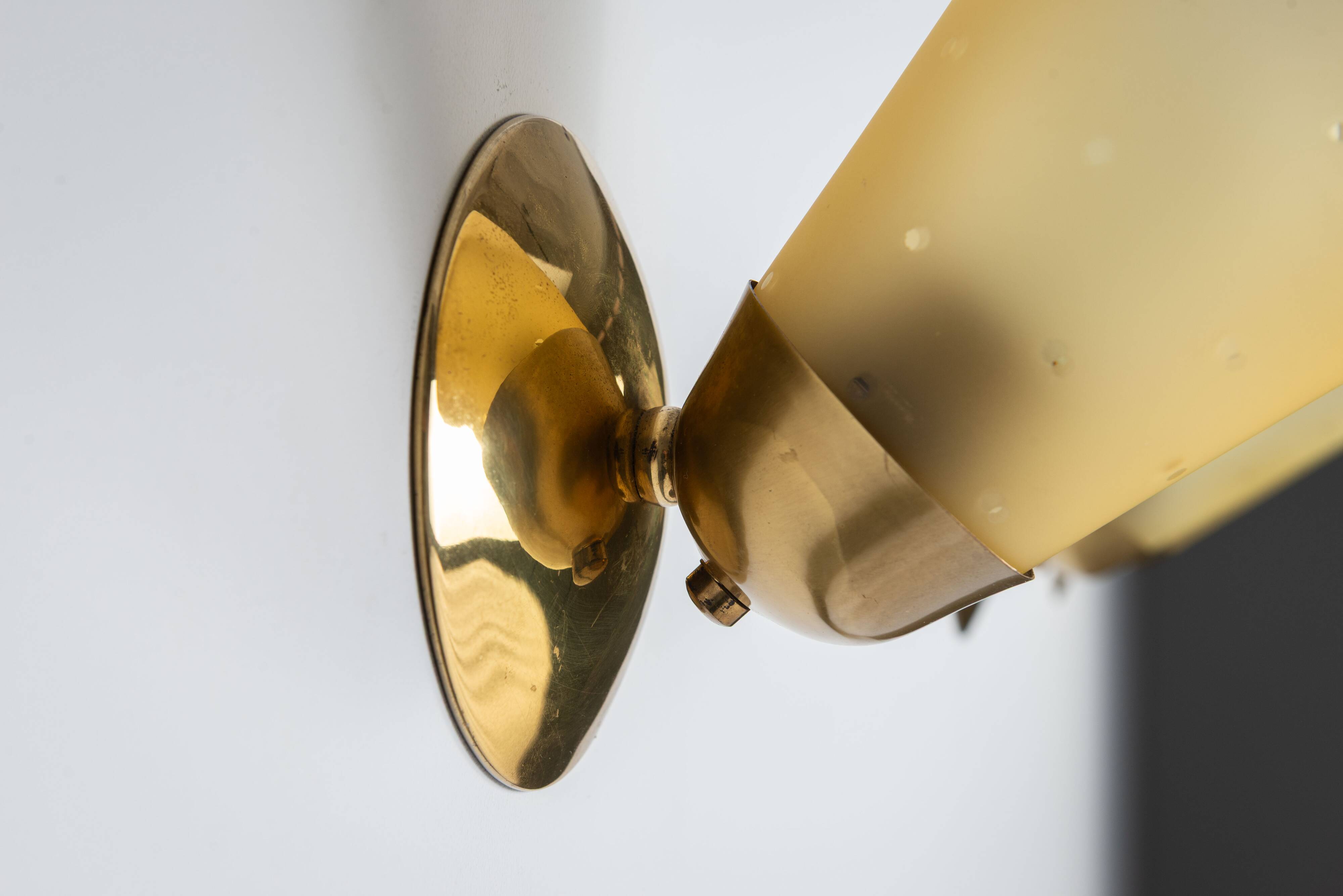 Set of three brass sconces with decorated yellow glass shades
