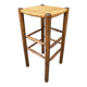 Old high bar stool in wood and straw