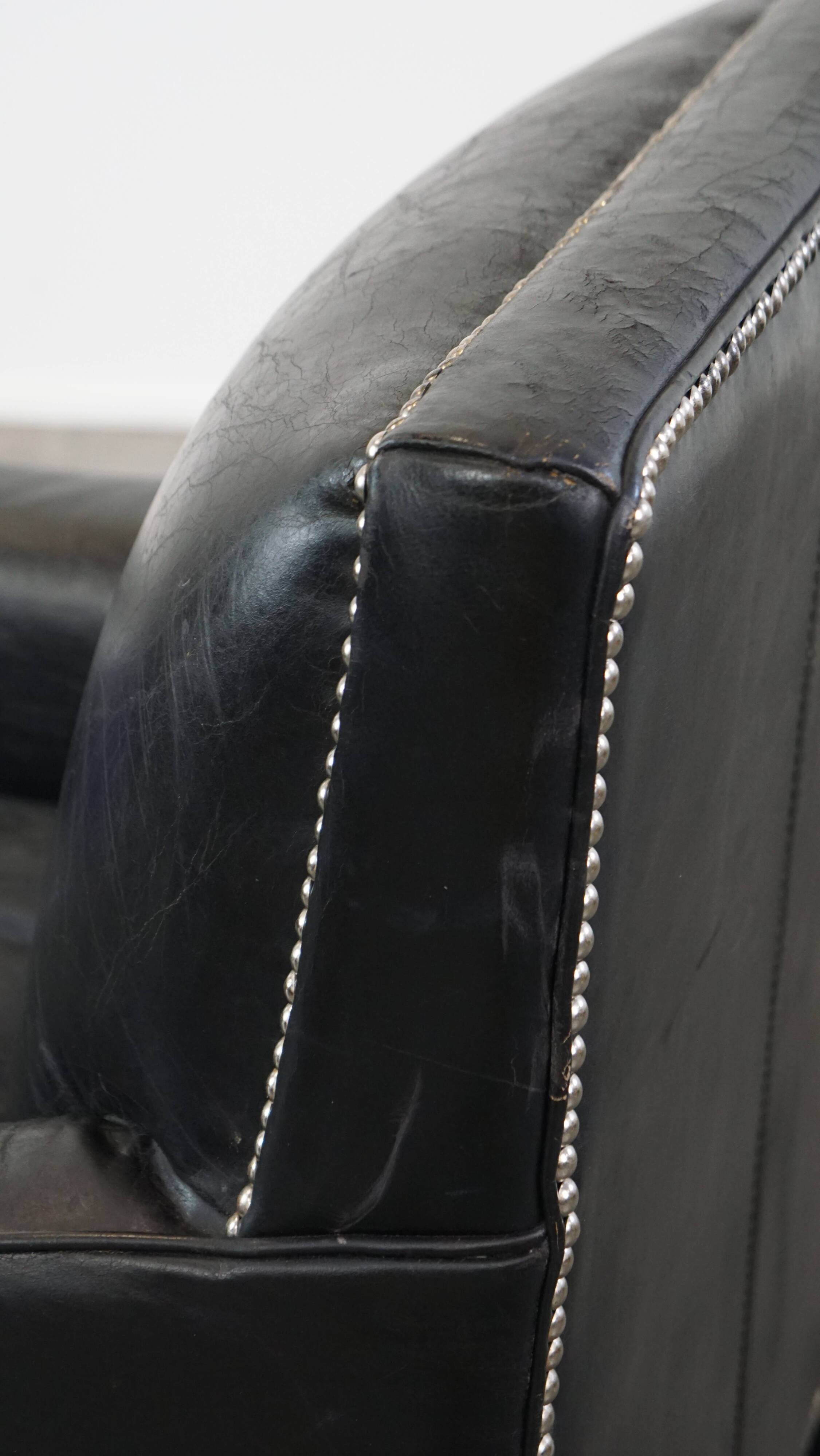 Armchair in black grained cowhide leather with a deep seat