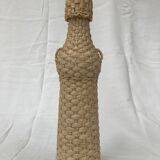 Bottle surrounded by wicker or raffia