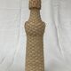 Bottle surrounded by wicker or raffia