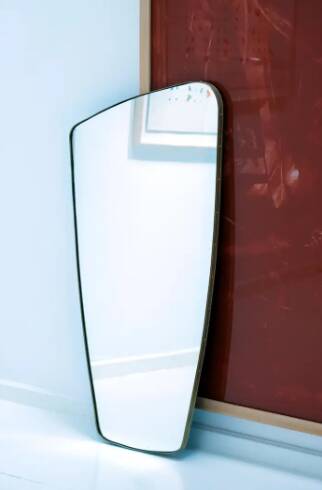 Contemporary rectangular mirror with rounded edges and embossed brass frame.