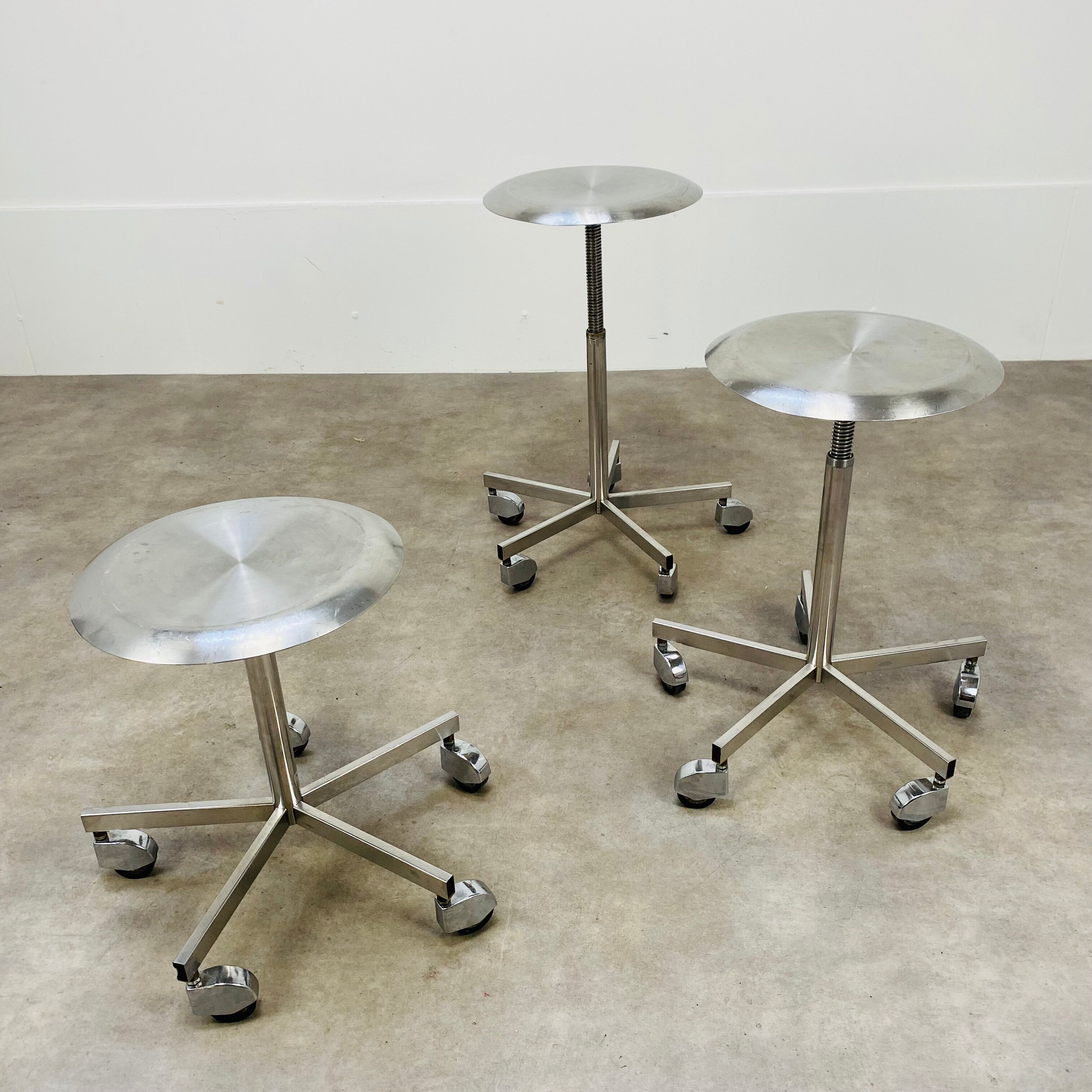 3 adjustable industrial stools with aluminum wheels