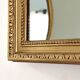 Antique mirror with a gilded frame and beaded border.