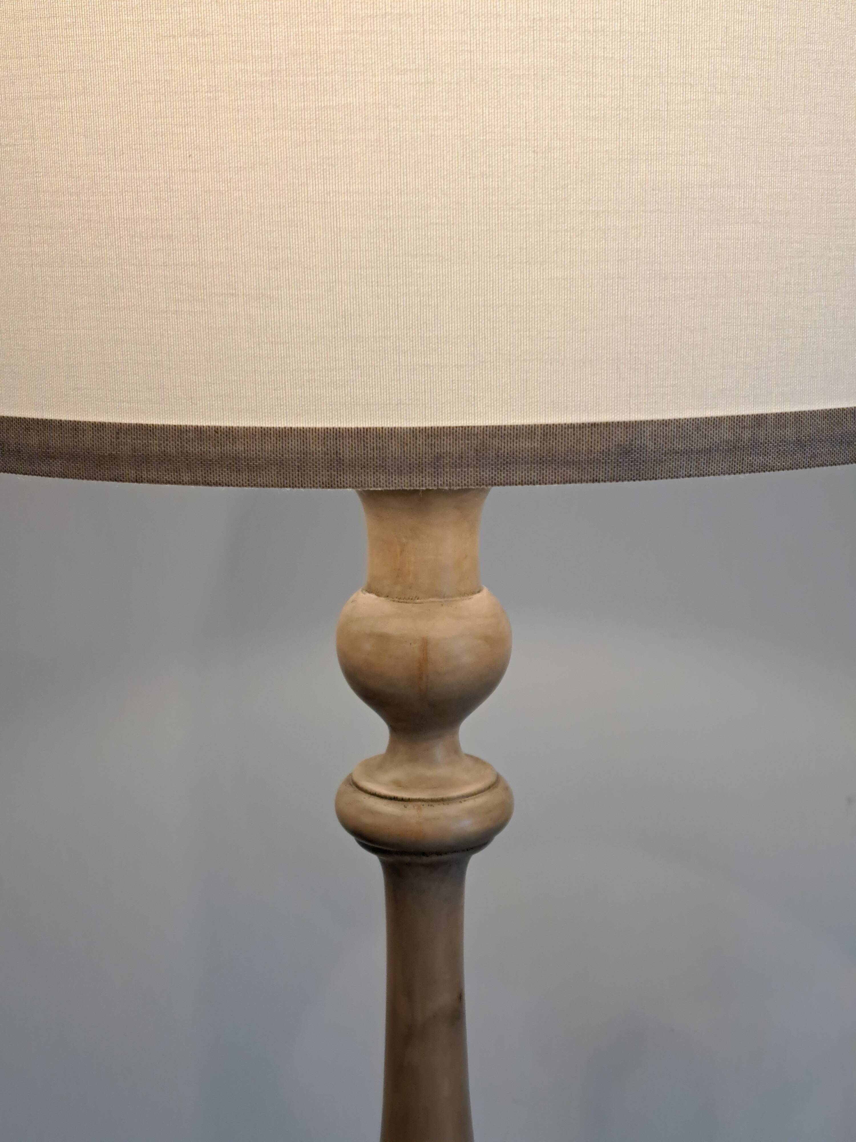 Vintage floor lamp in turned wood with an aged effect.