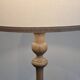 Vintage floor lamp in turned wood with an aged effect.