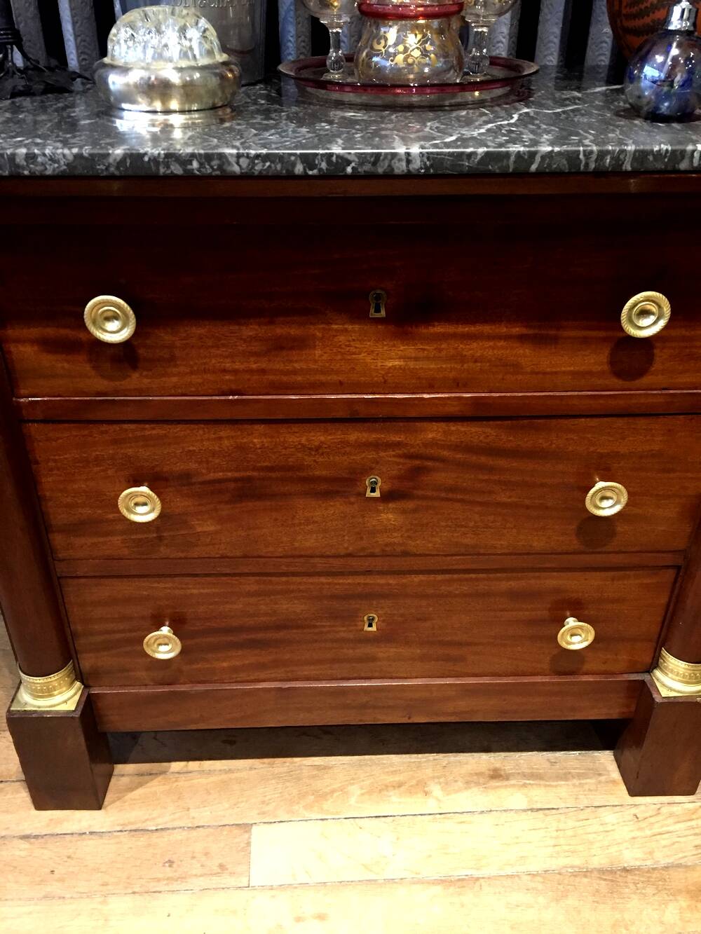 Empire chest of drawers with half columns in mahogany and gilded bronze