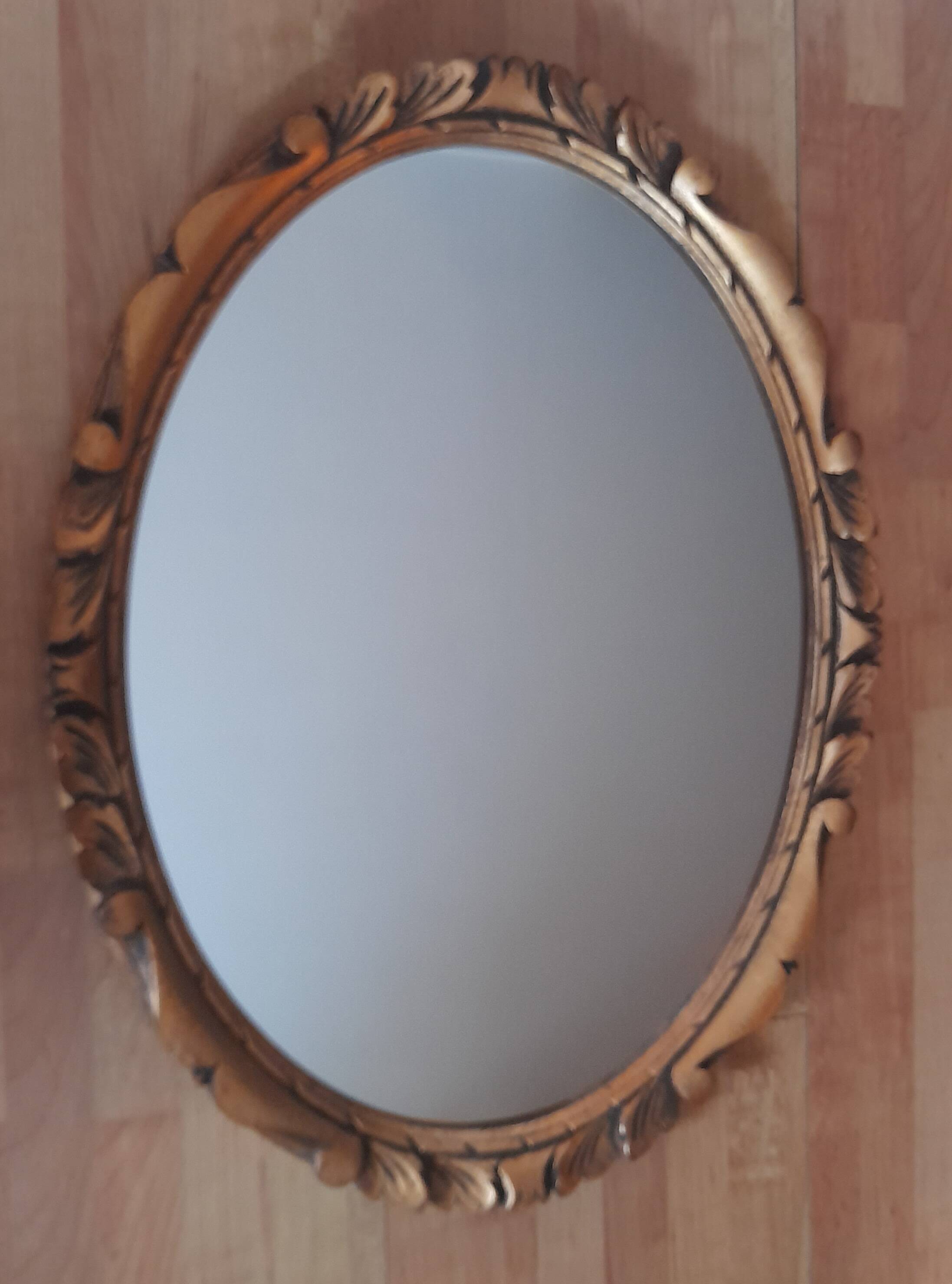 Oval wall mirror in gilded wood