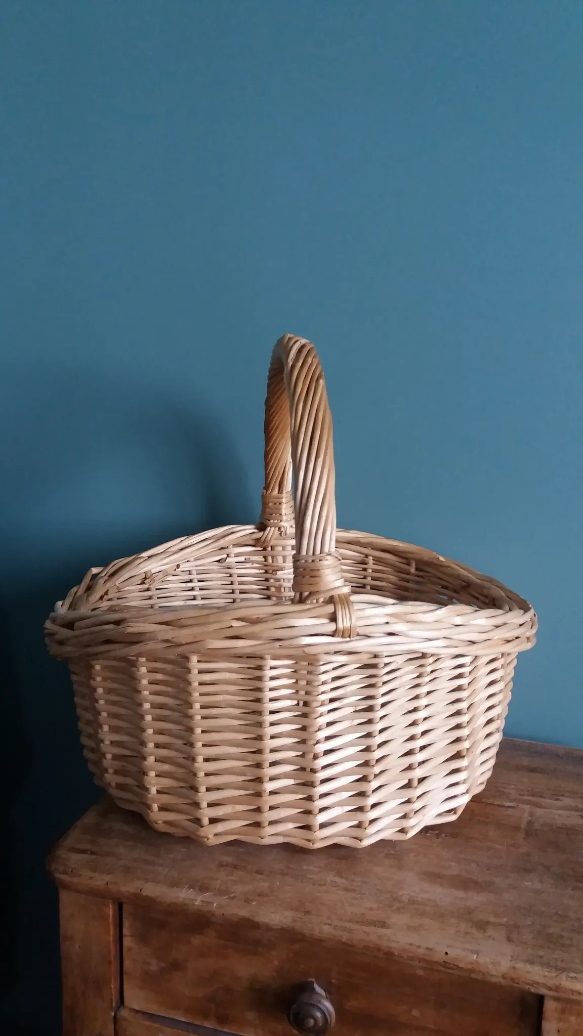 Handcrafted wicker basket with a handle.