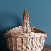 Handcrafted wicker basket with a handle.