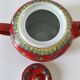 Vintage red Chinese teapot decorated with dragons and symbols.
