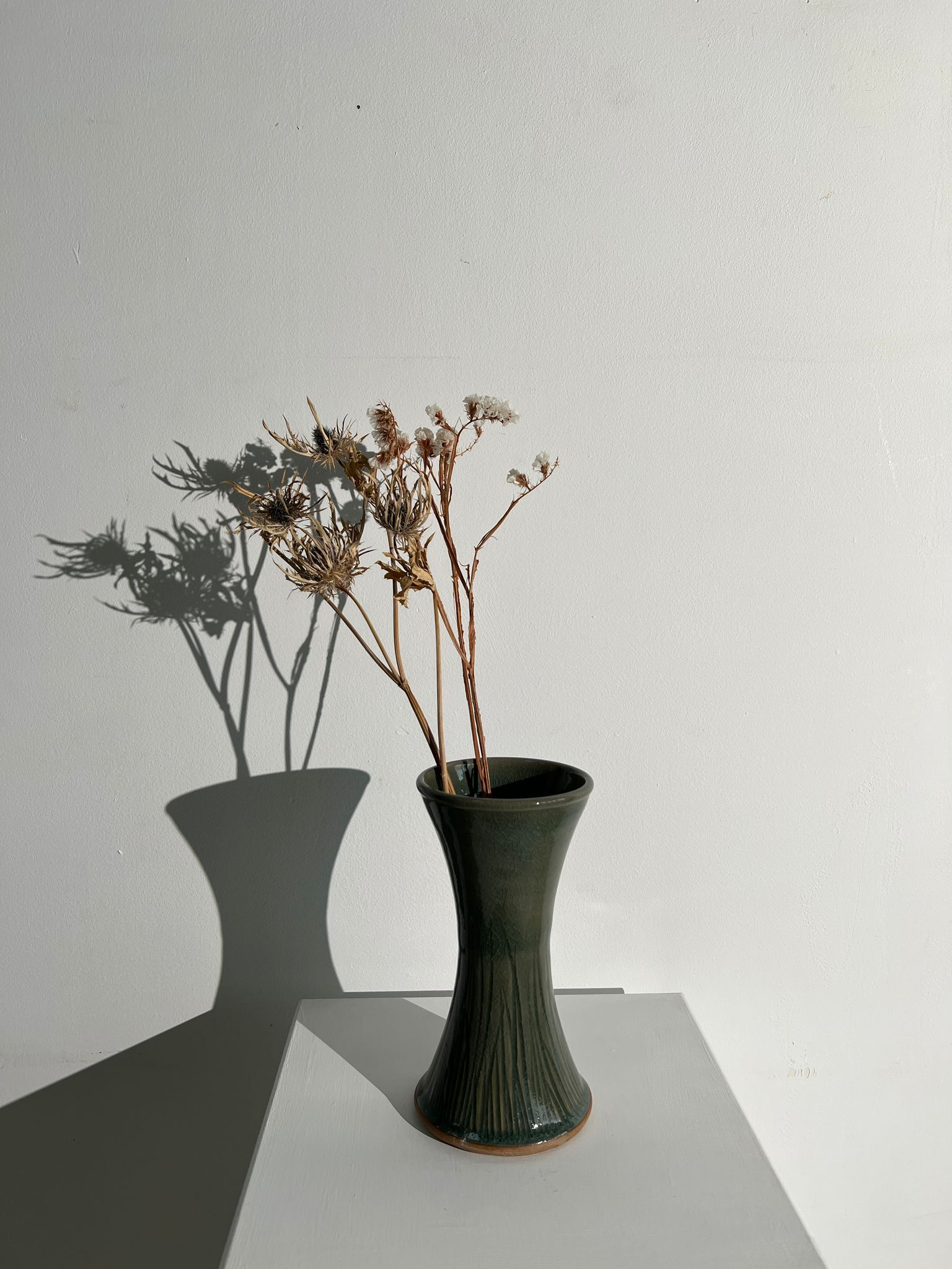 Dark green handcrafted vase with glazed ceramic grass blades