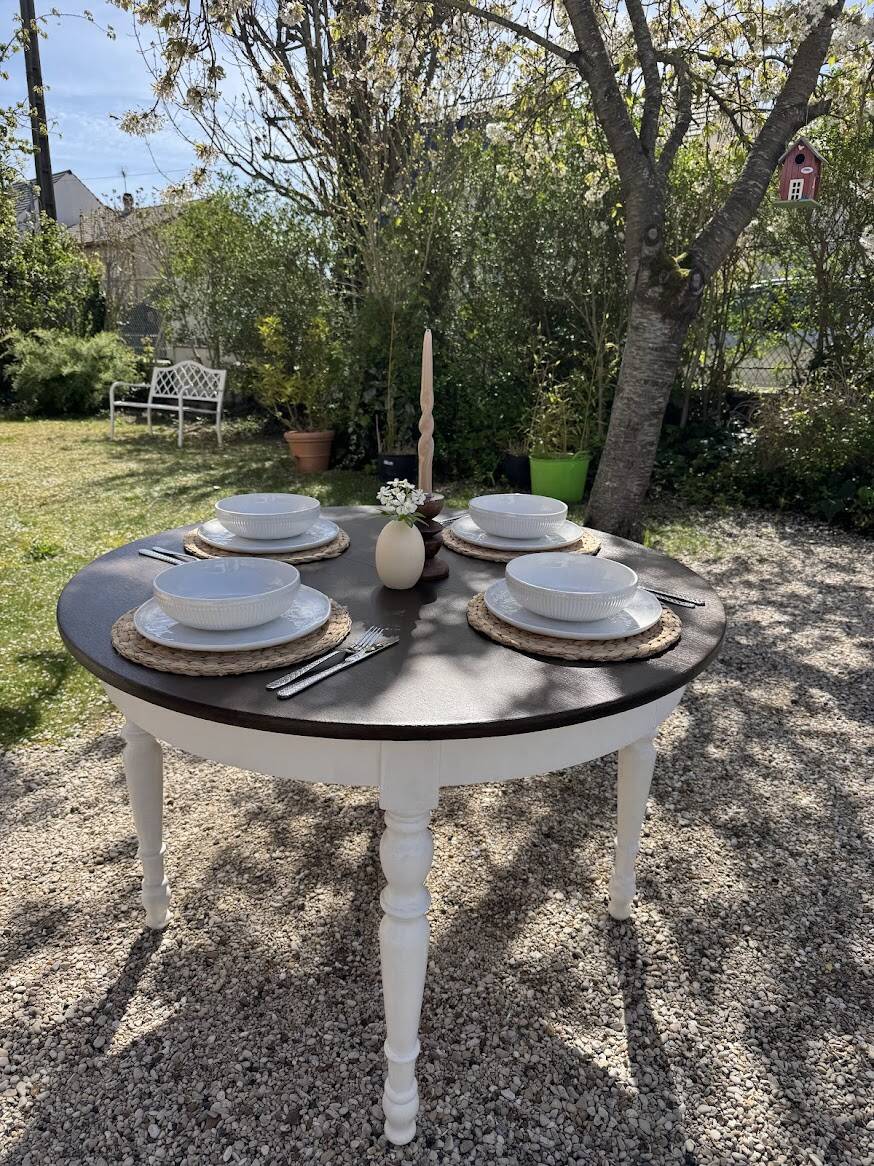 Restored solid wood round table with integrated extensions.