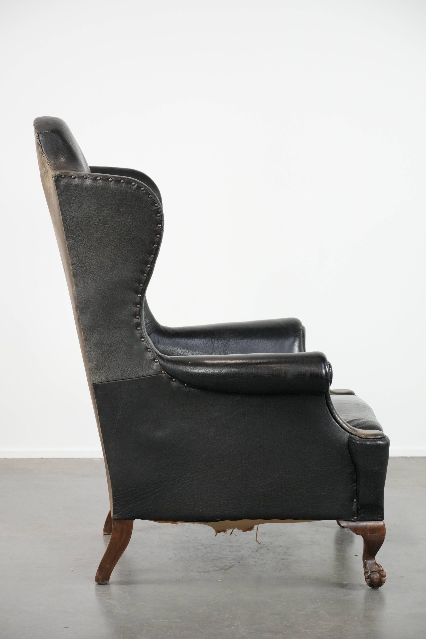 Antique black English cow leather wingback armchair from the 19th century