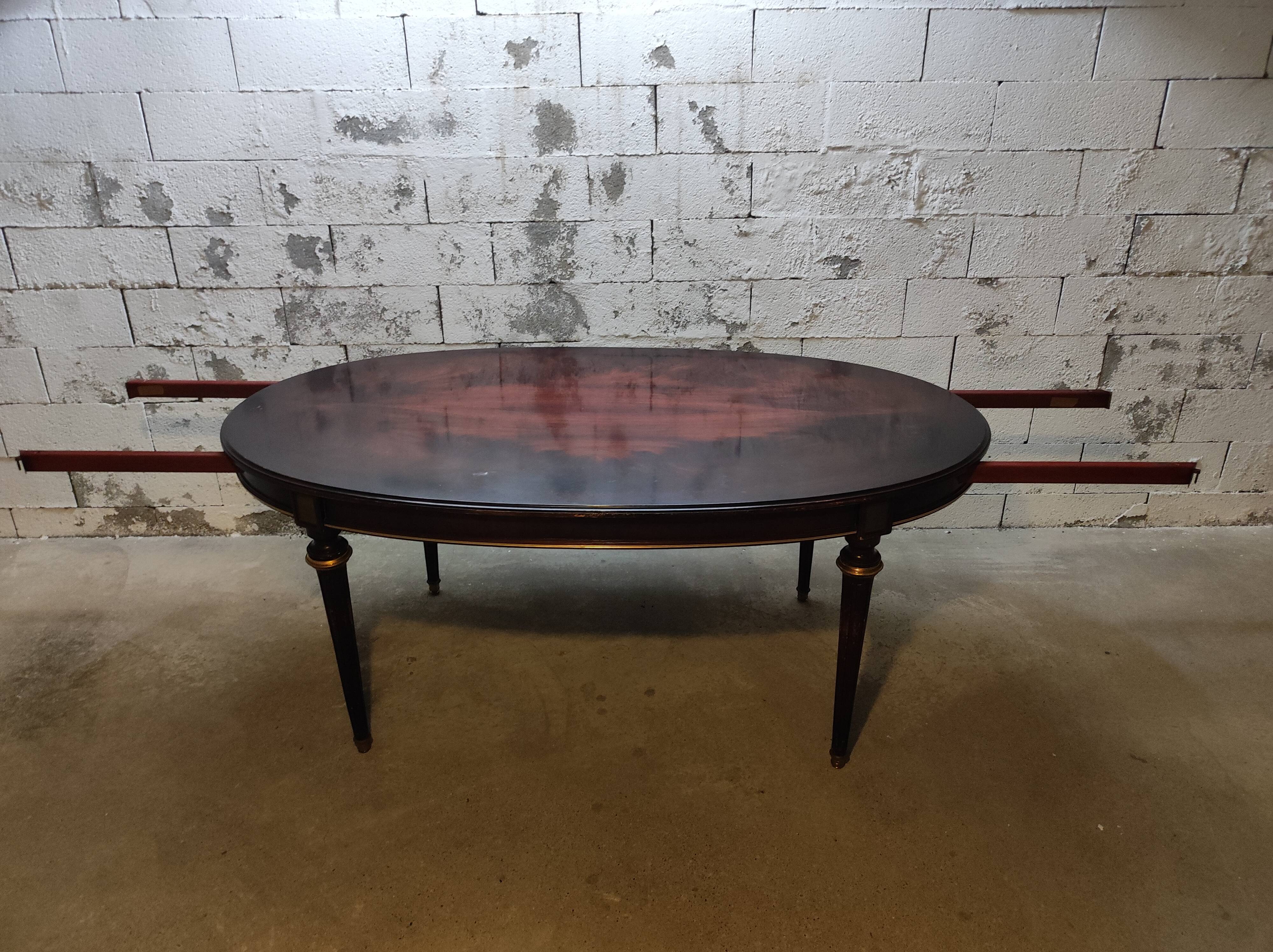 Oval Louis XVI style table with half-moon extensions.