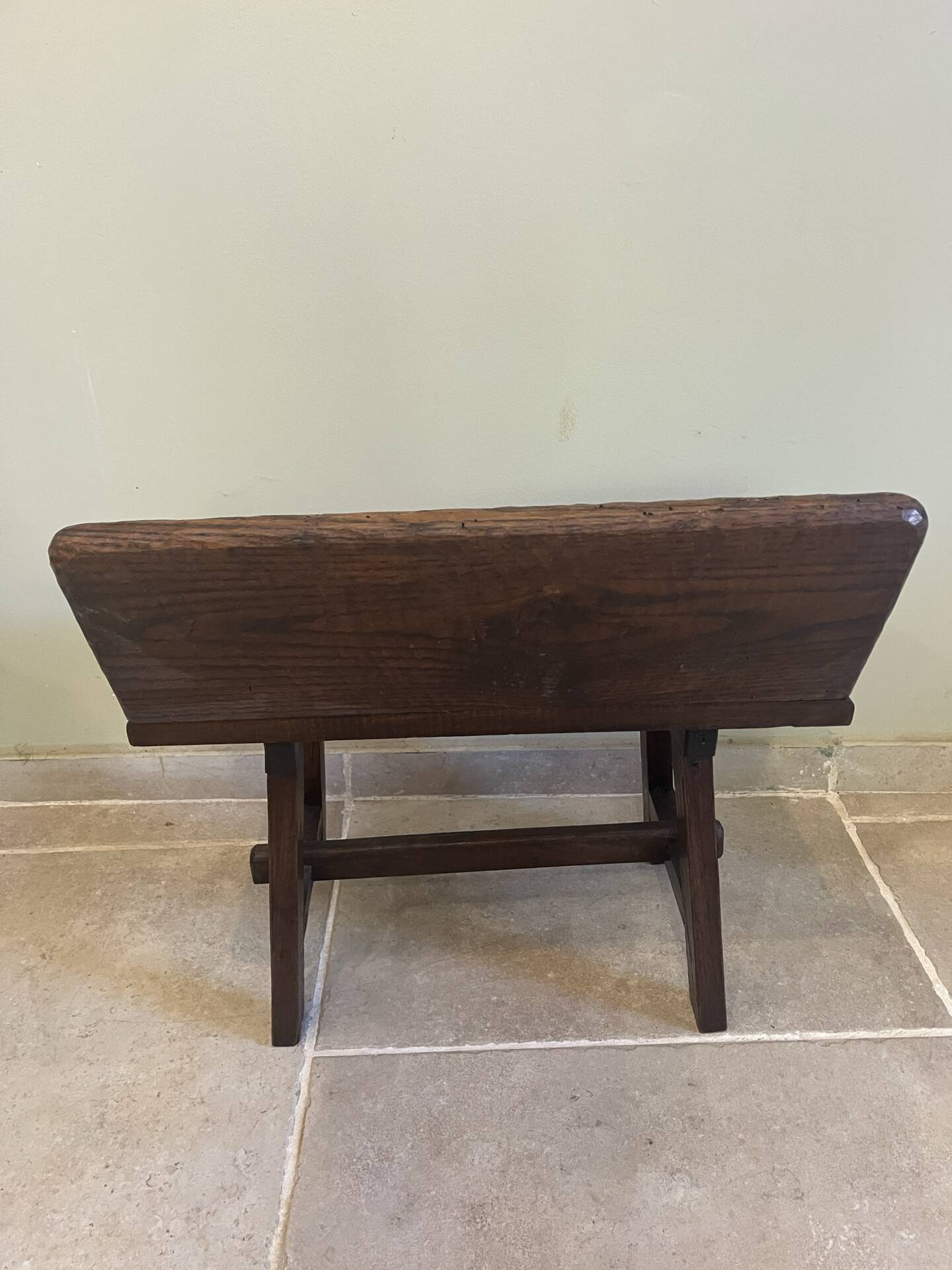 Small antique wooden bench with a folding backrest.