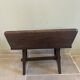 Small antique wooden bench with a folding backrest.